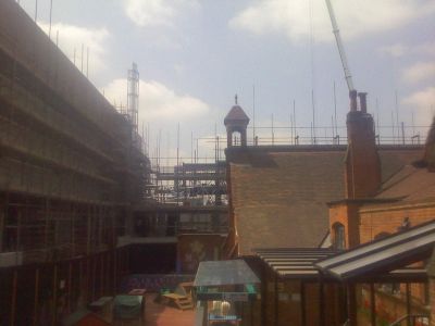 Side of Leisure Centre and Scaffolding for Residential Building Behind Church
